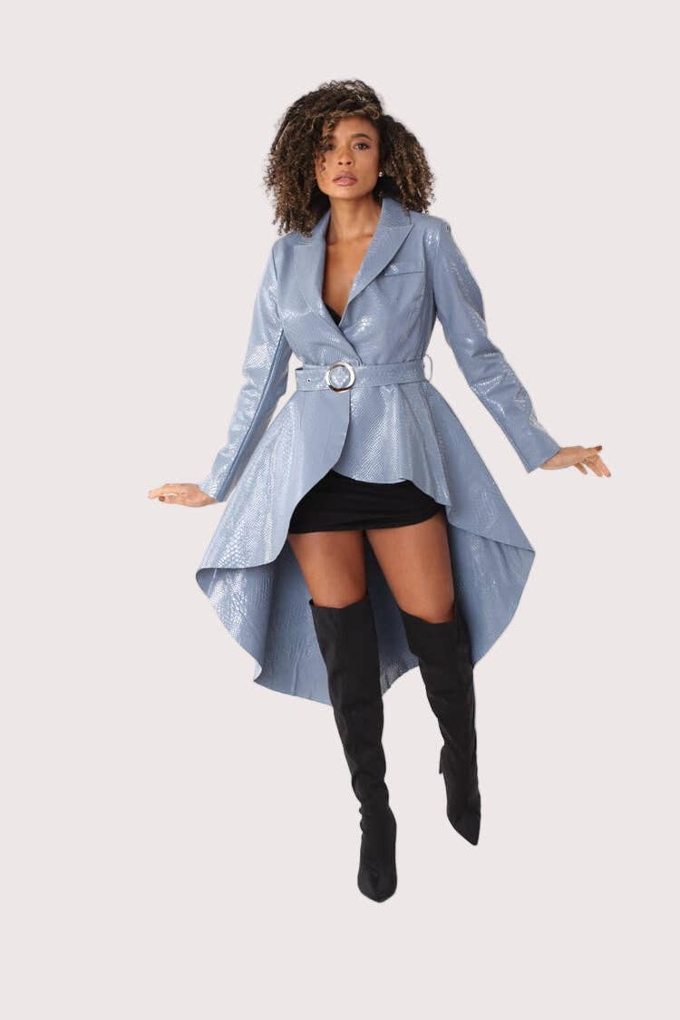 Woman wearing a light blue trench coat with a belt, black skirt, and knee-high black boots on a white background.