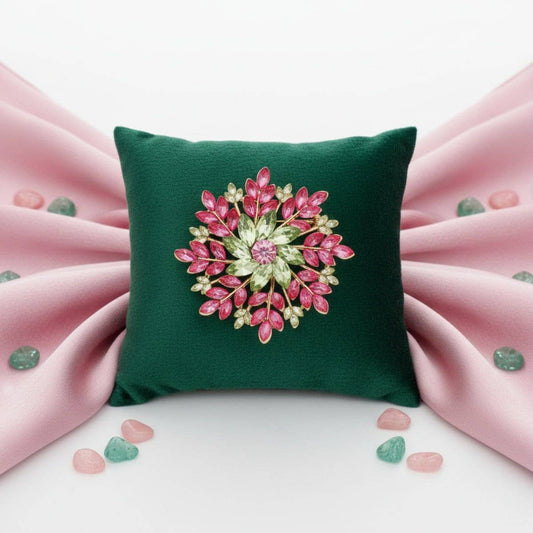 Green pillow with a decorative brooch on a pink fabric background