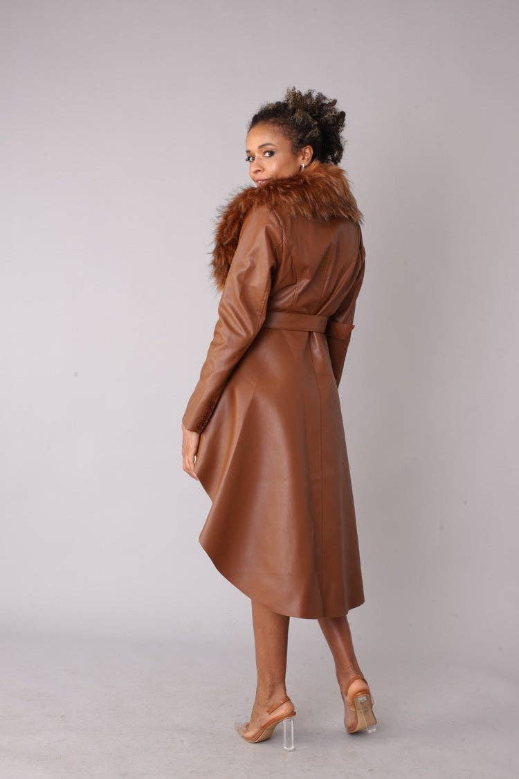 Woman wearing a brown leather coat with fur collar on a plain background