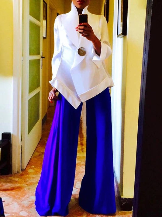 Person wearing a white jacket and blue pants taking a mirror selfie.