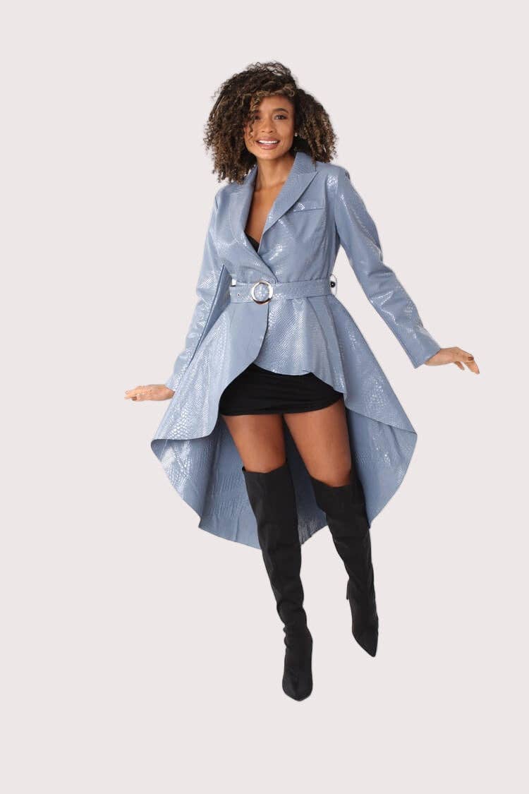 Woman wearing a long light blue coat over a black outfit on a white background