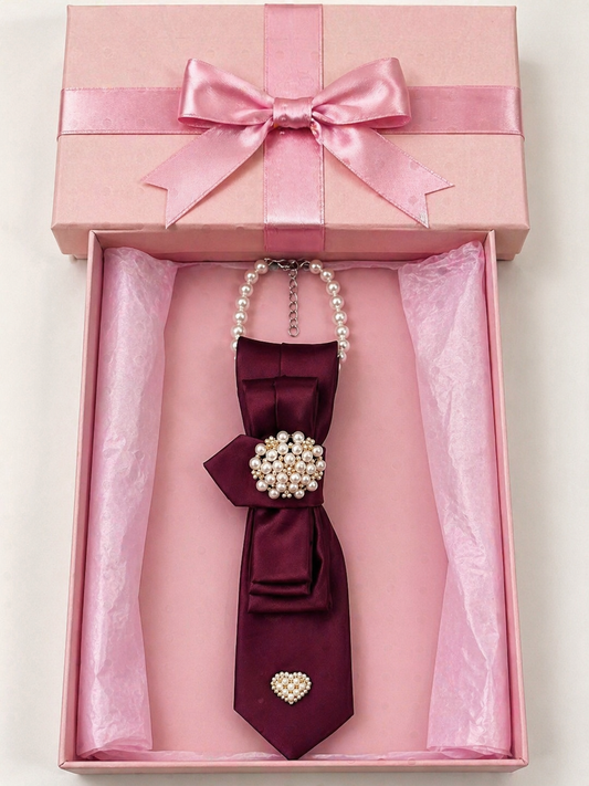 Maroon bow tie with pearl embellishments in a pink gift box.