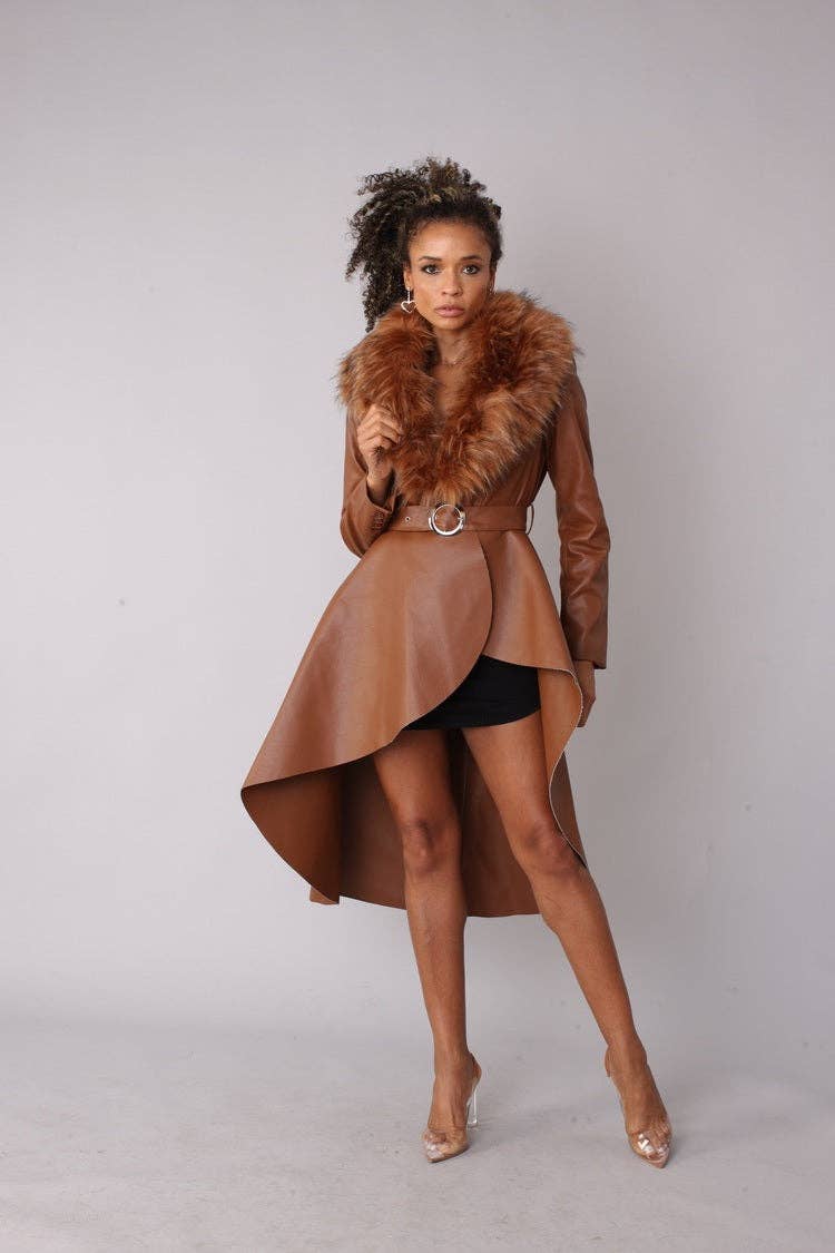 Woman wearing a brown coat with fur collar on a plain background