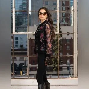 Woman standing in front of a reflective glass wall with cityscape background