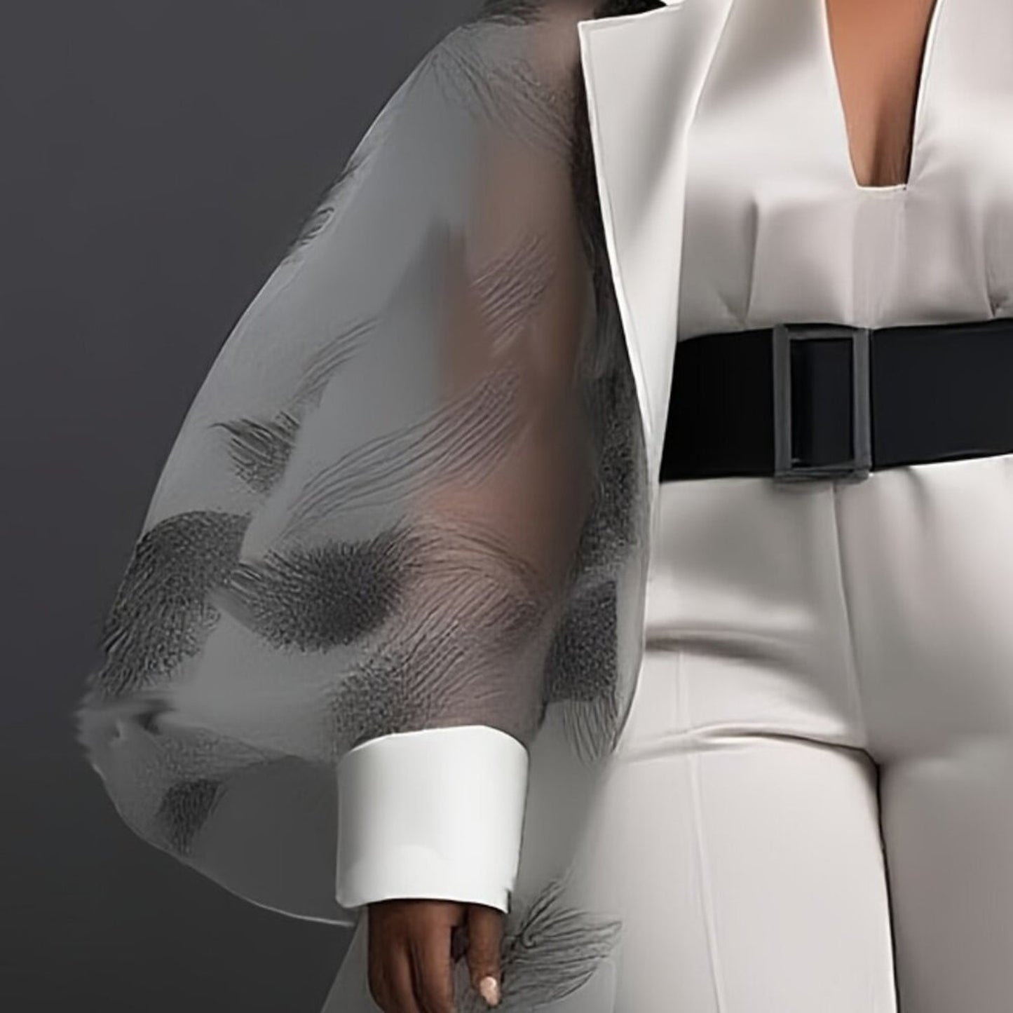 White outfit with sheer sleeves and a black belt on a dark background