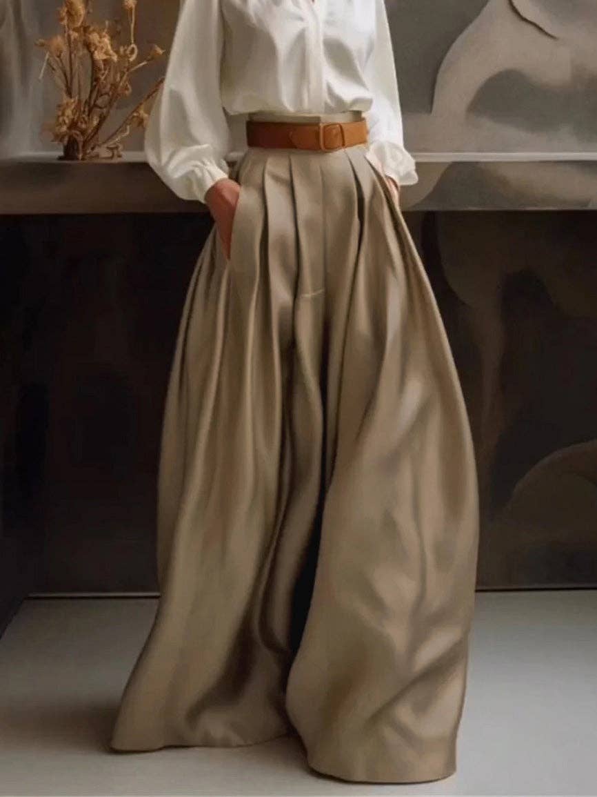 Person wearing a white shirt and beige wide-leg pants with a brown belt.