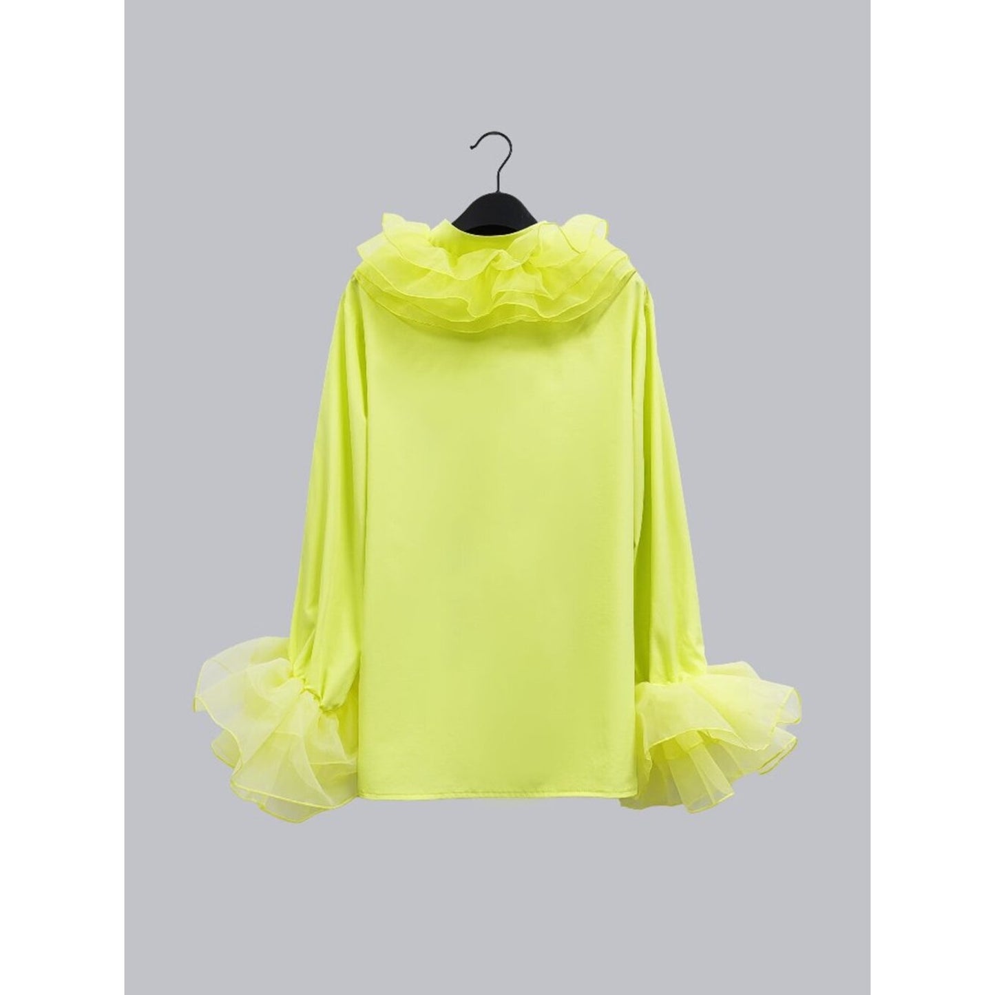 Yellow hooded garment with ruffled details on a hanger against a gray background