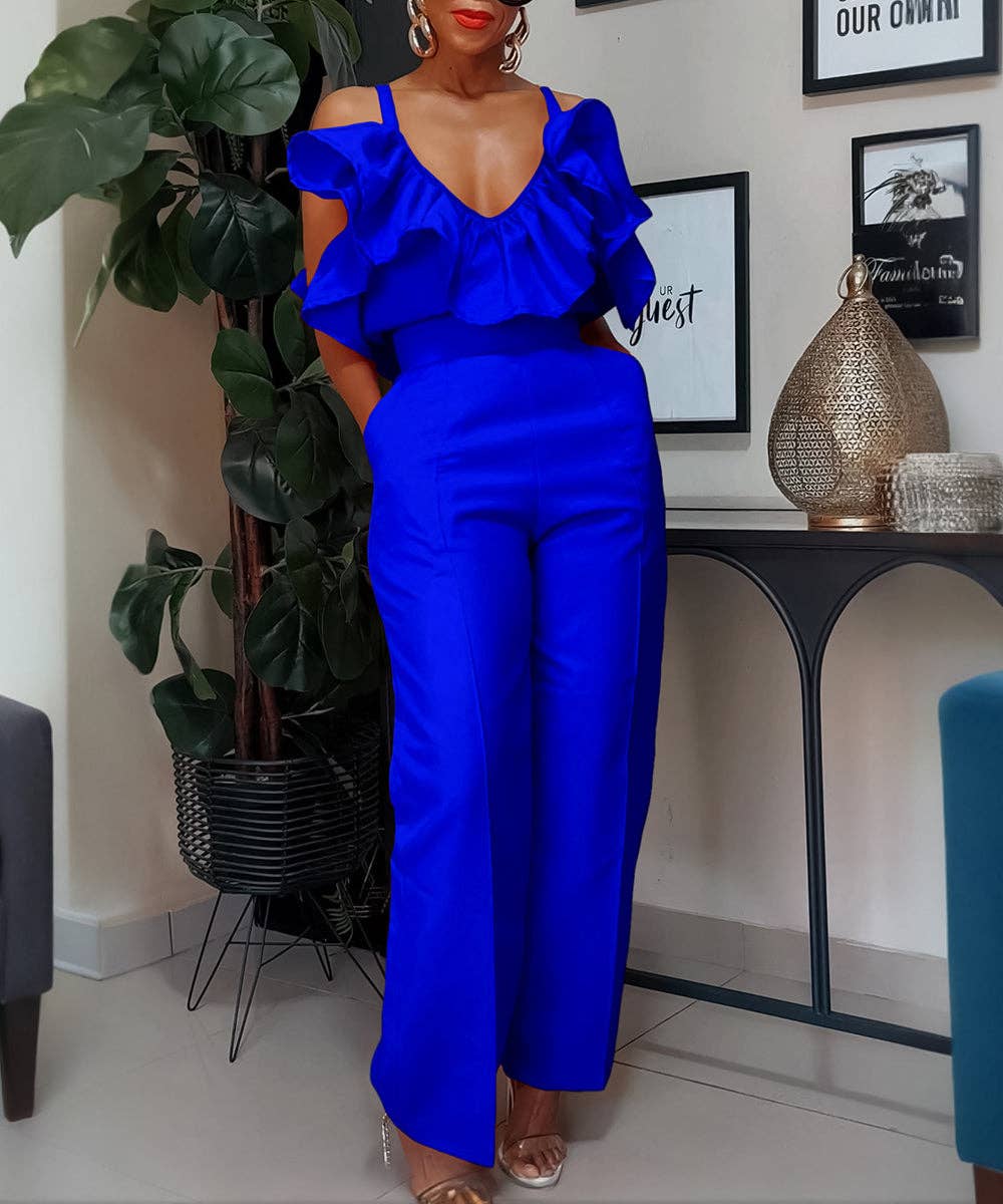 Woman in a blue outfit standing in a room with decor elements.