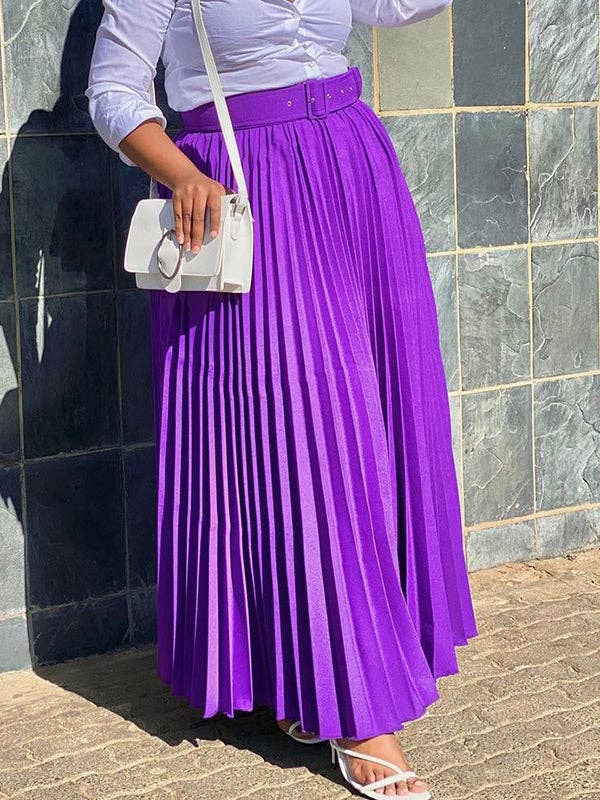 Person wearing a purple pleated skirt and white top against a tiled wall.