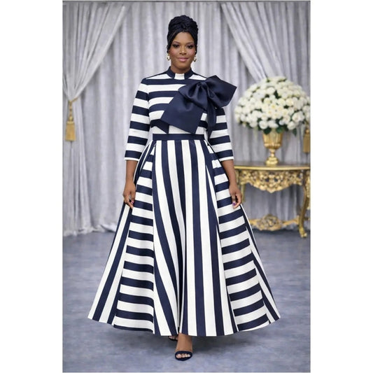 Woman wearing a black and white striped dress with a large bow in a decorated room.