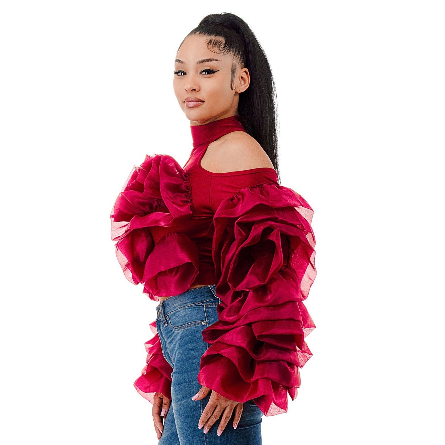 Woman wearing a red ruffled blouse and blue jeans on a white background