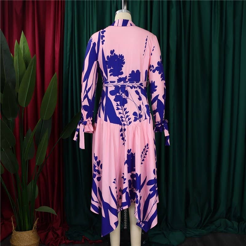 Pink dress with blue floral pattern on a mannequin against a green curtain background