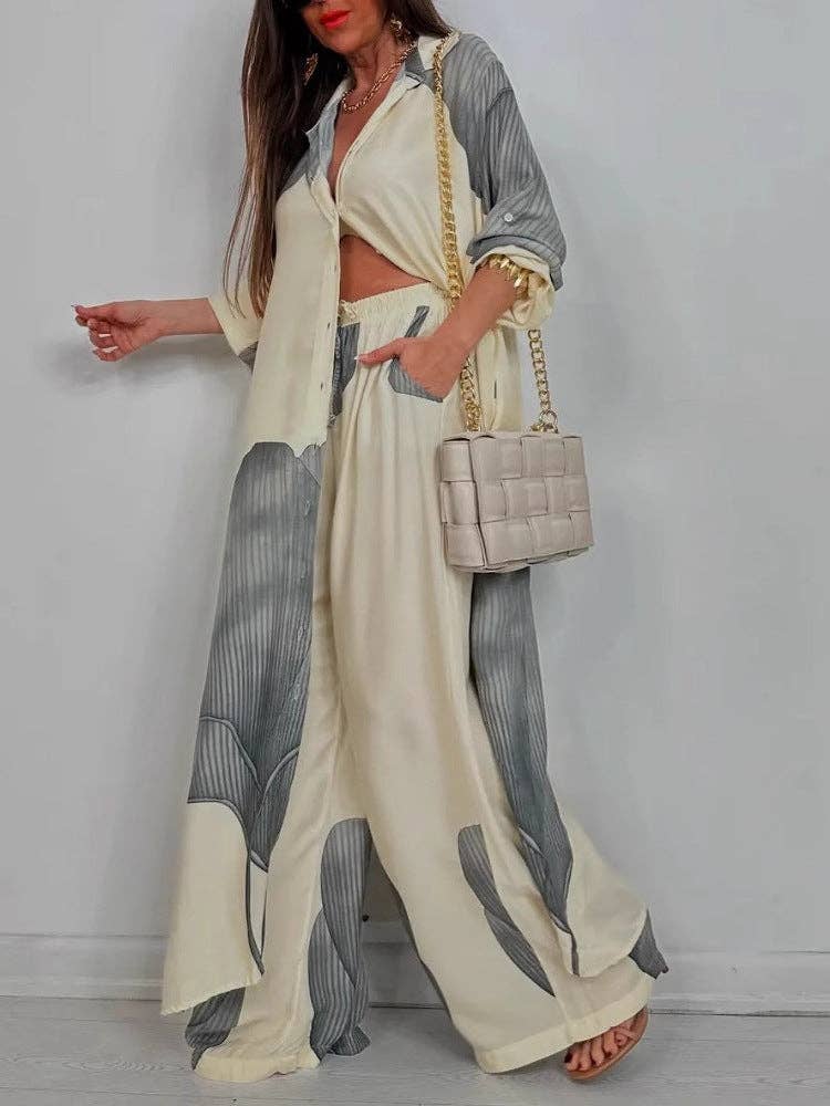 Woman wearing a stylish outfit with a white and gray pattern, holding a beige handbag.