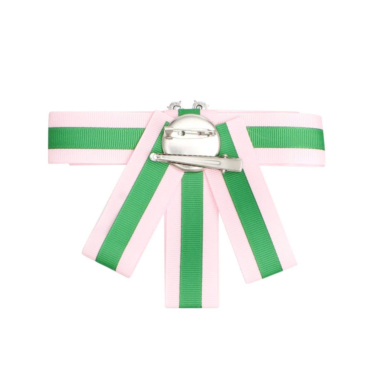 Pink and green ribbon with a metal clasp on a white background