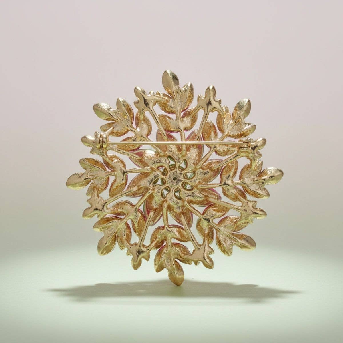 Gold snowflake-shaped brooch on a light background