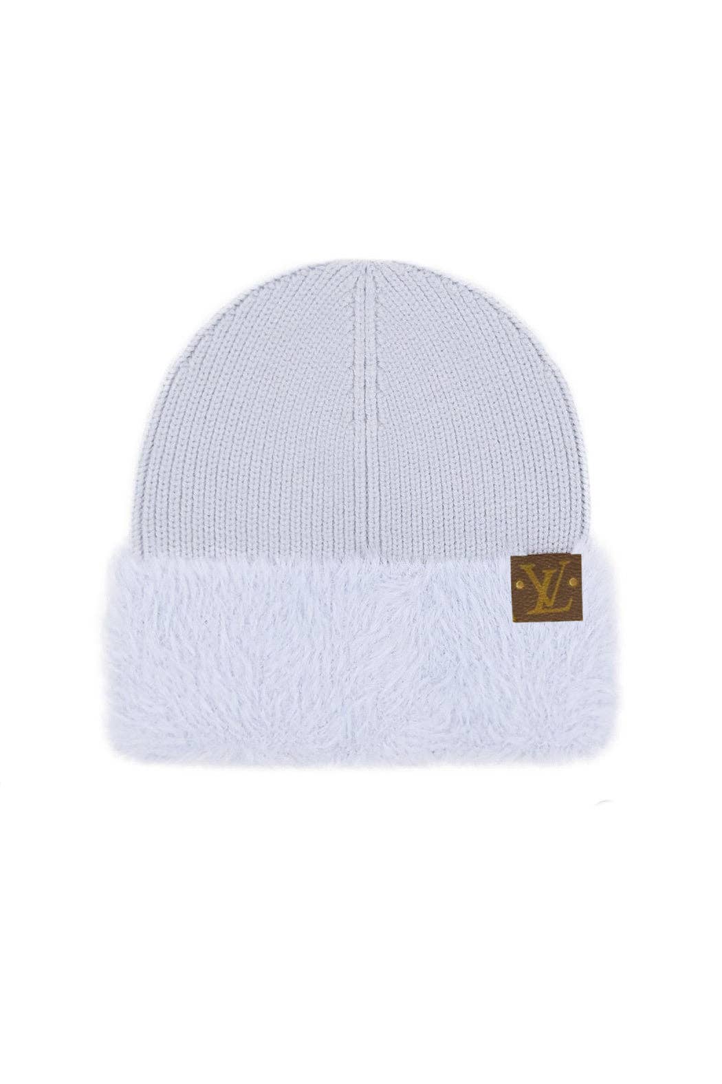 White beanie with a gold logo patch on a white background