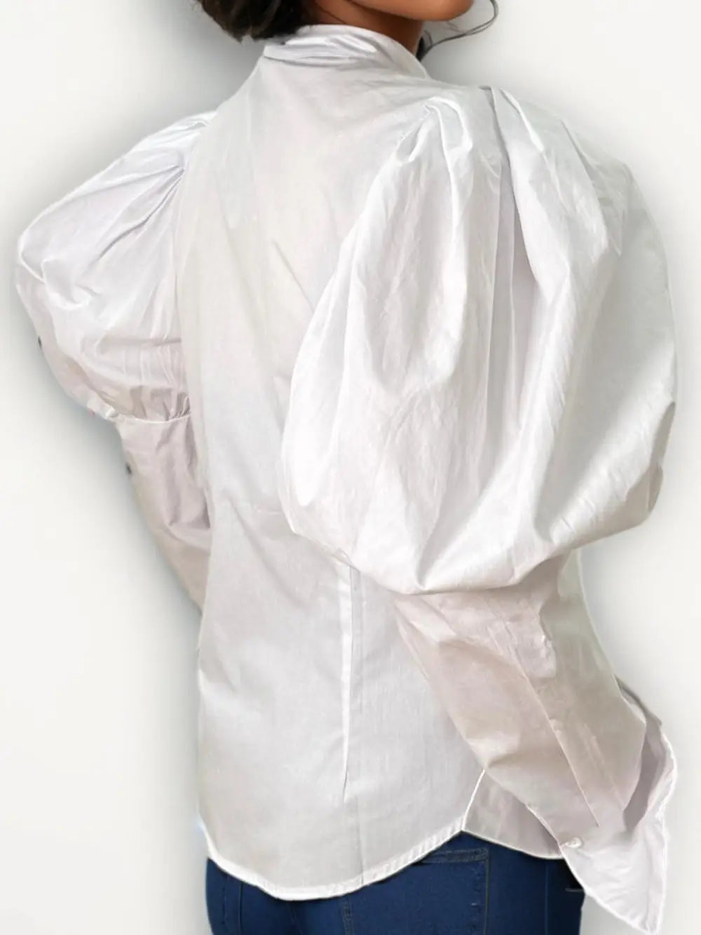 White blouse with sheer sleeves worn by a person on a white background