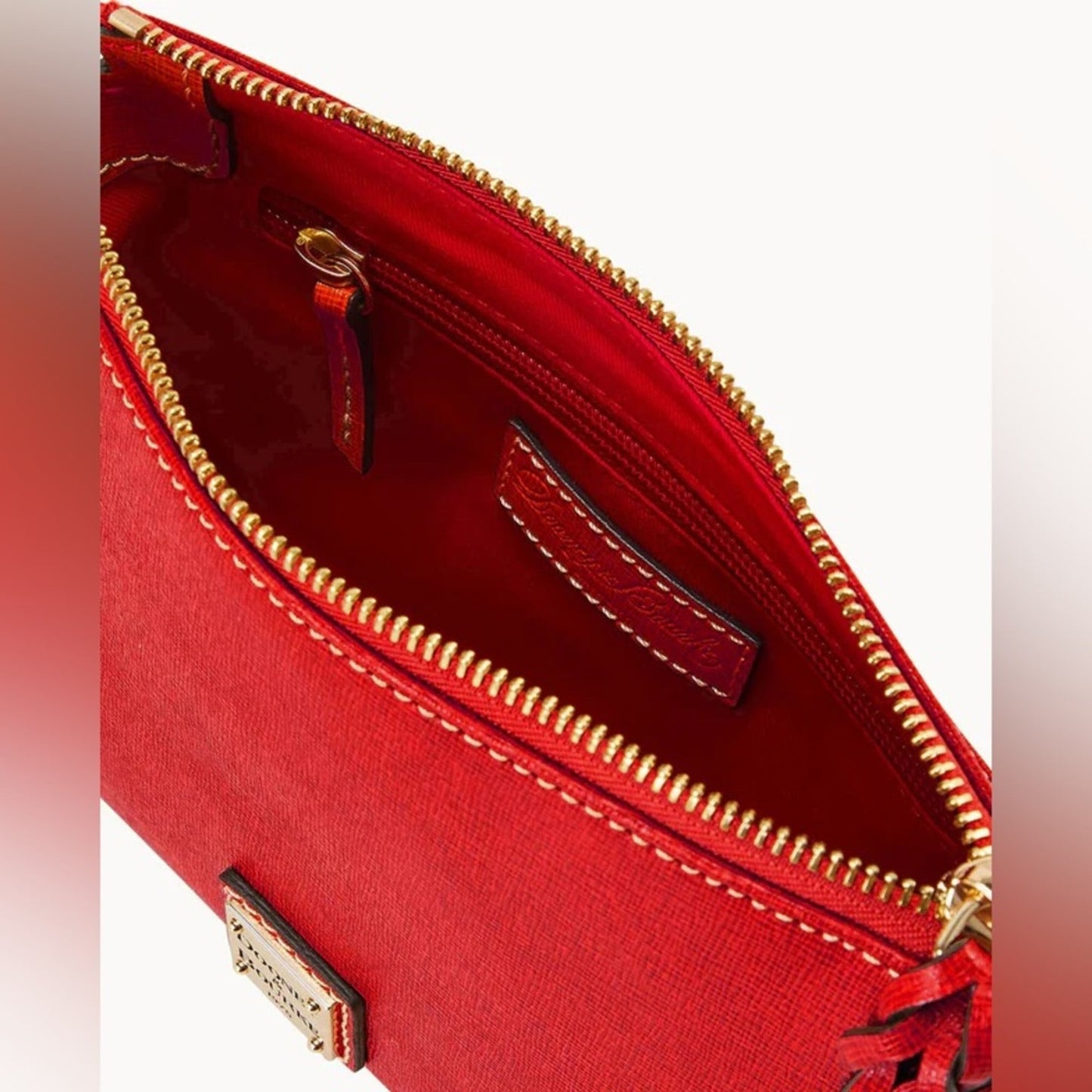 Red handbag with gold zipper and stitching on a white background