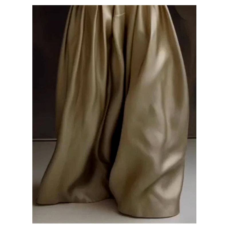 Gold satin fabric draped over a surface with a dark background