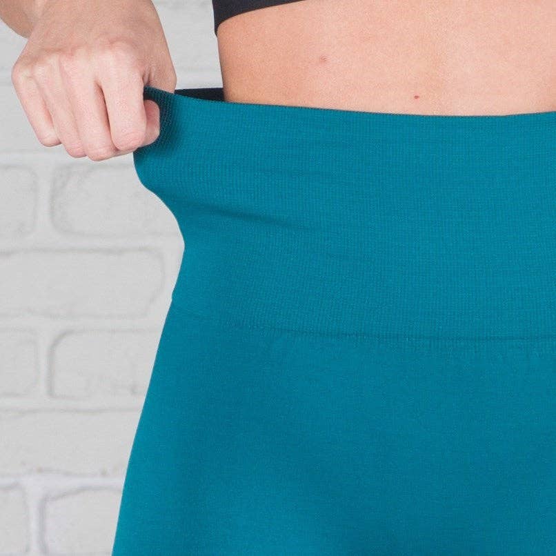 Teal skirt being held up against a light gray background