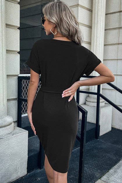 Woman wearing a black dress standing on steps outside a building.