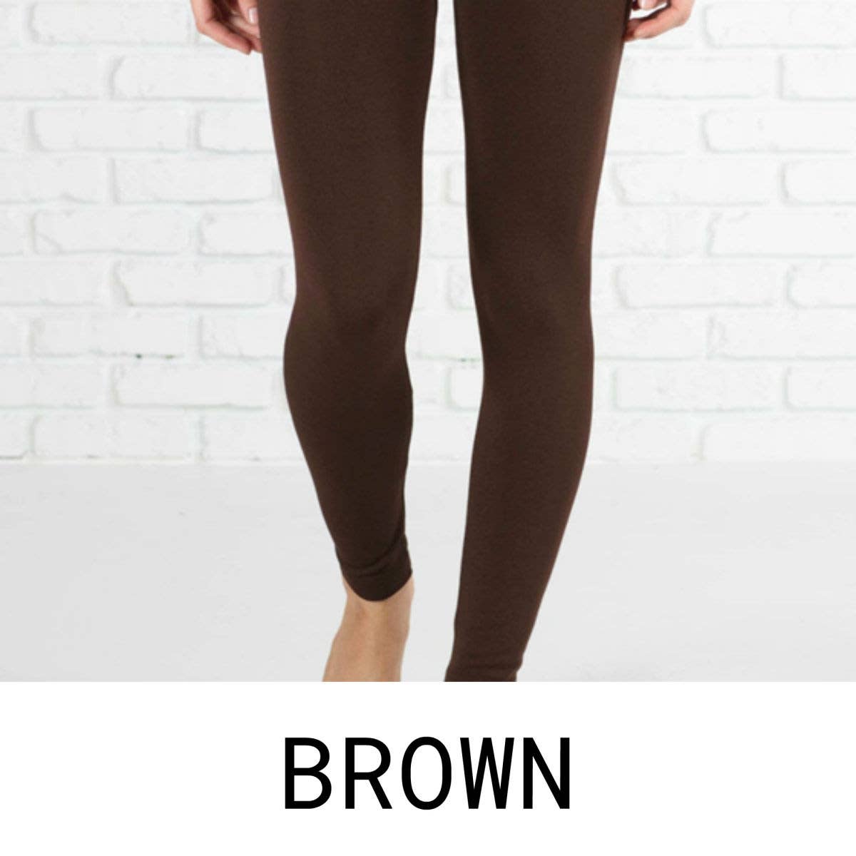 Brown leggings worn by a person against a white brick wall.