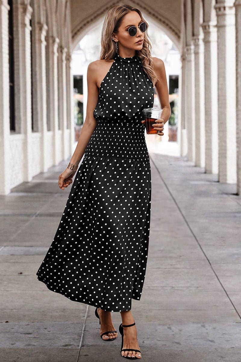 Woman wearing a black polka dot dress in an outdoor setting