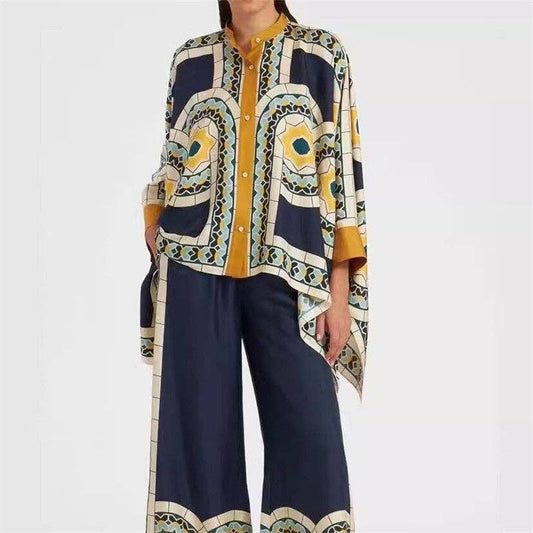 Woman wearing a patterned blouse and navy pants on a white background