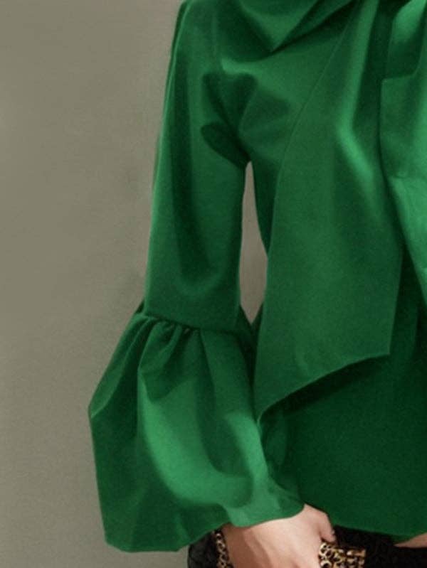 Green blouse with ruffled sleeves on a plain background