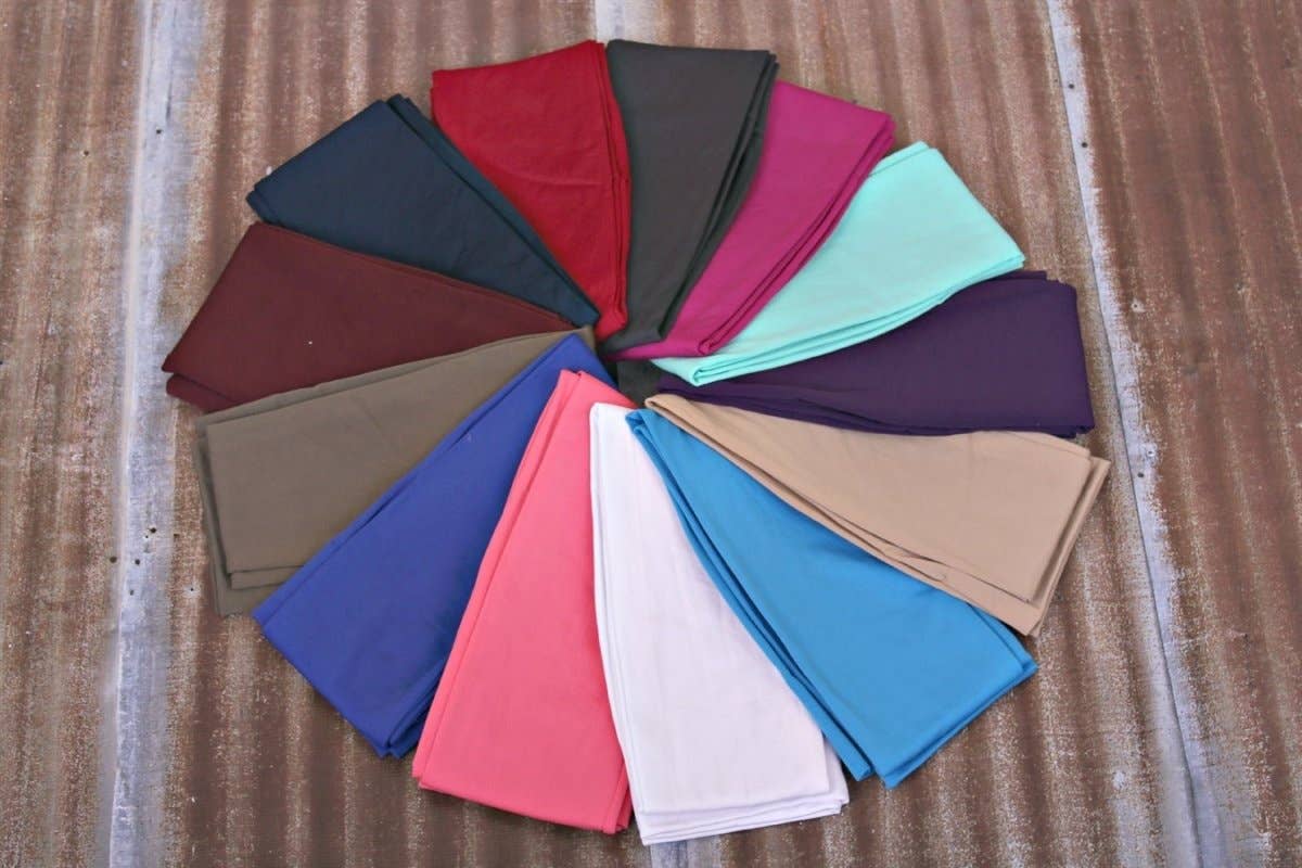 Circular arrangement of folded fabric swatches in various colors on a wooden surface.