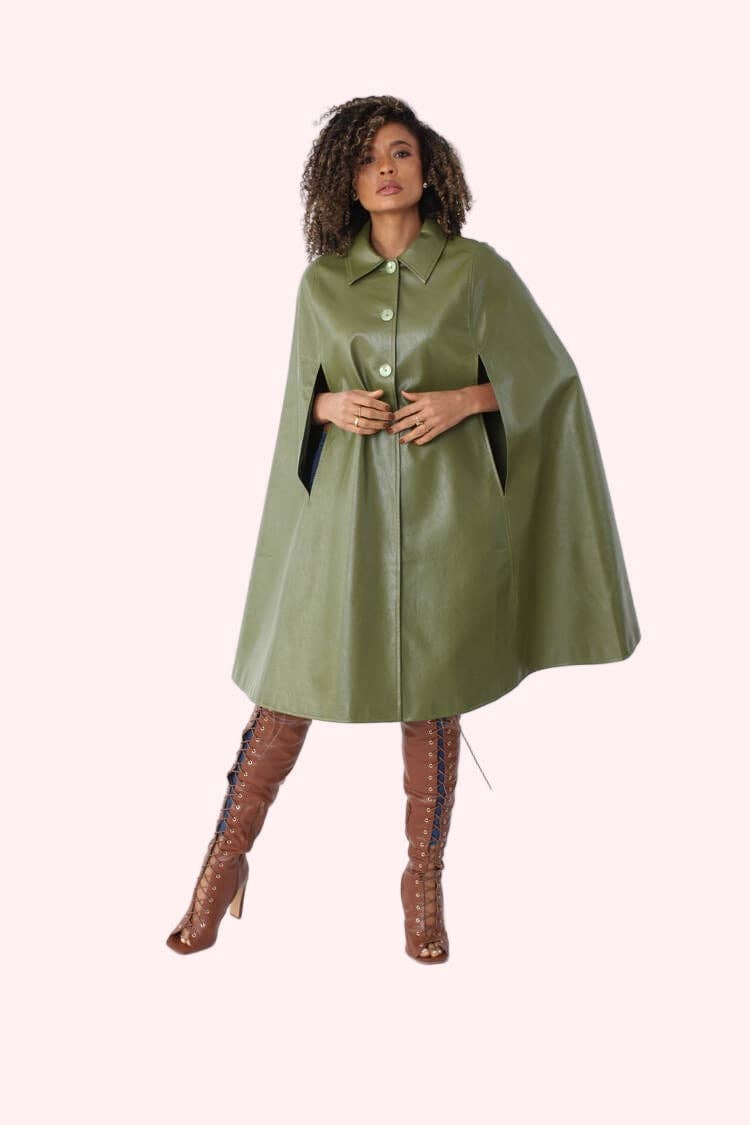Woman wearing a green leather cape on a white background