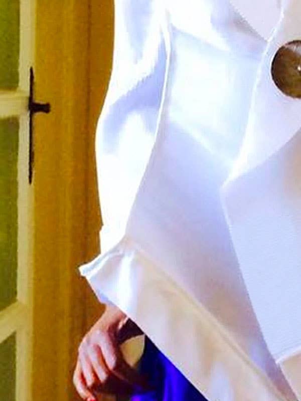 Close-up of a white shirt with a button, blurred background