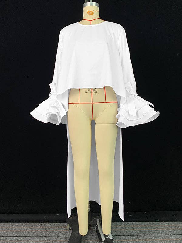 Mannequin wearing a white blouse and beige pants on a black background
