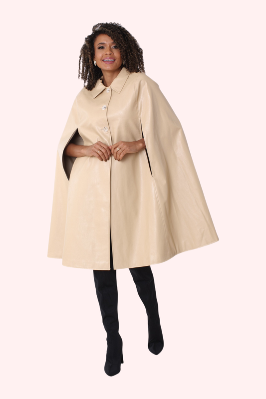 Woman wearing a beige cape over a black outfit on a white background