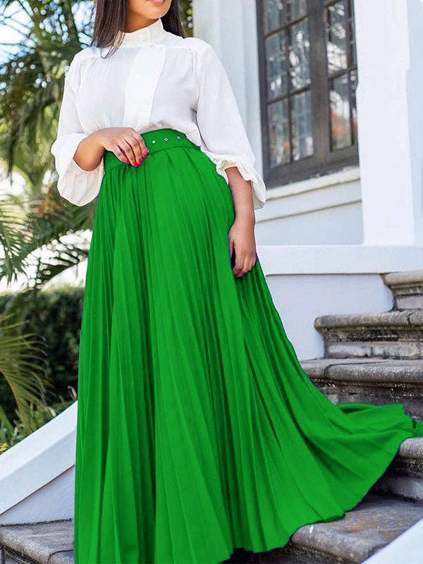 Woman wearing a white blouse and green skirt standing on steps outdoors.