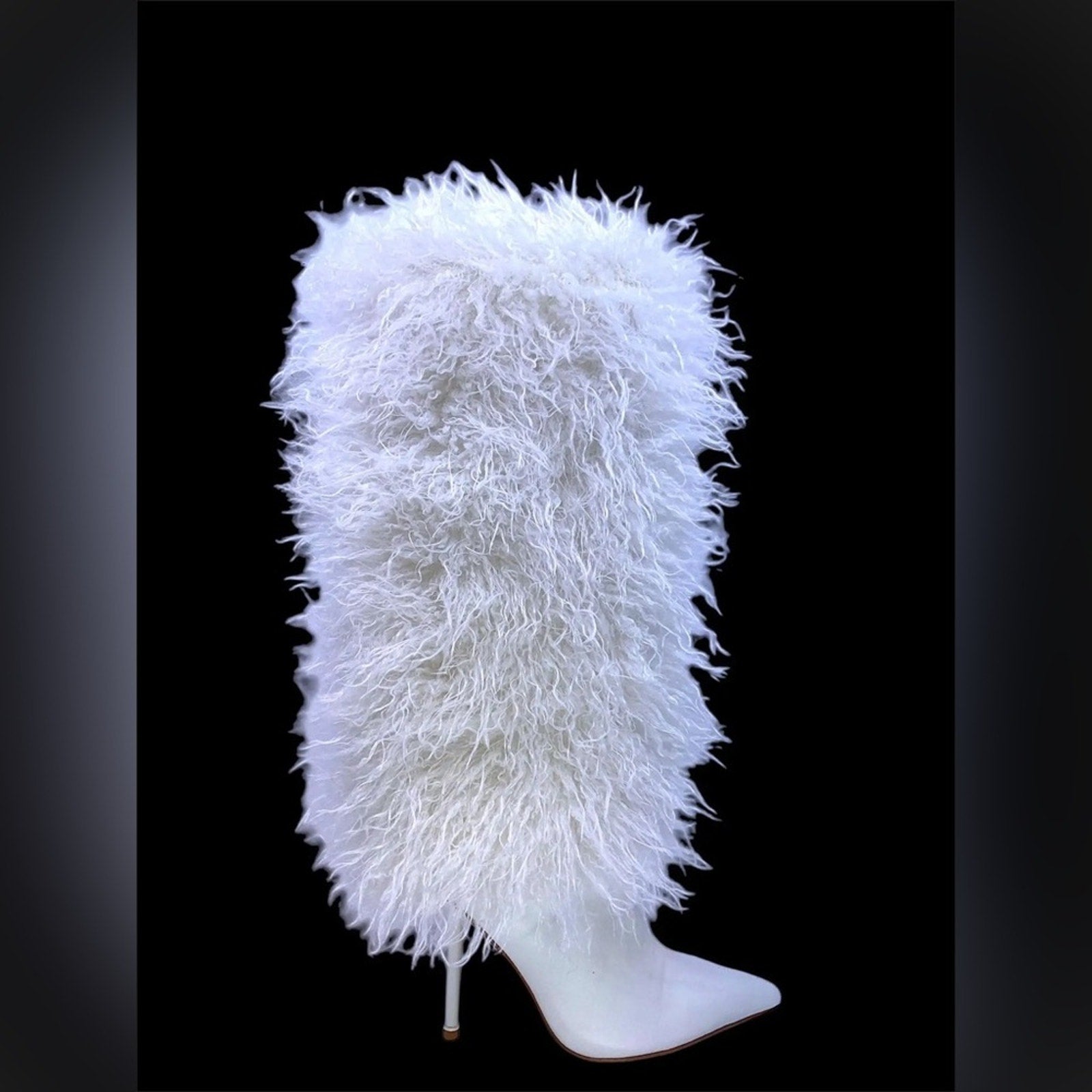 White feathered headpiece on a mannequin head against a black background