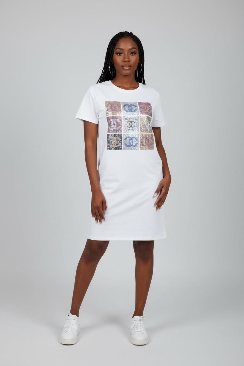Woman wearing a white t-shirt dress with graphic design on a plain background