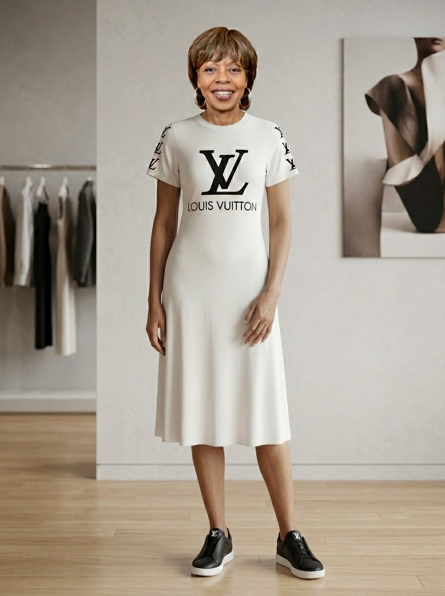 Woman wearing a white dress with a black logo in a room with clothing racks and a painting.