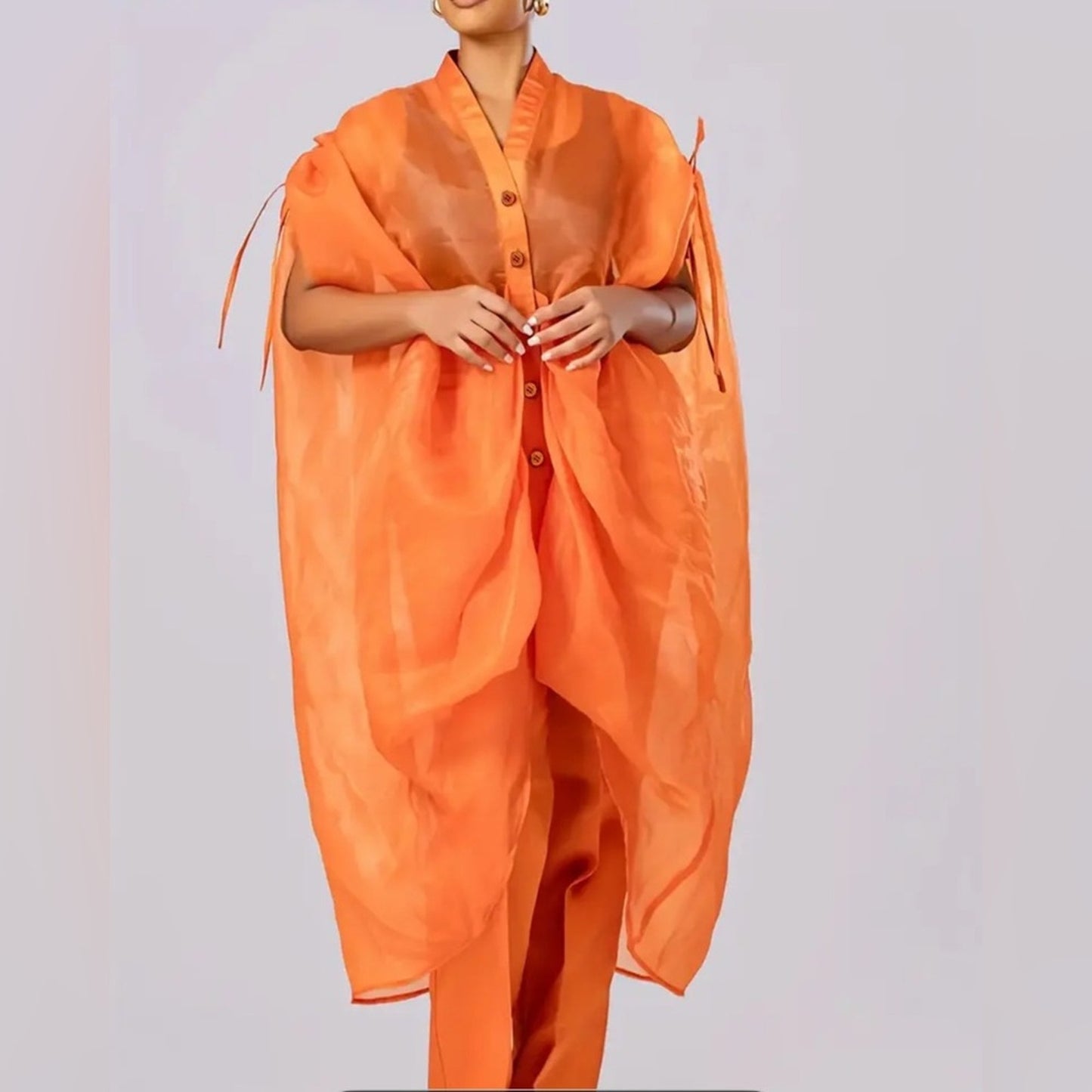 Orange outfit with a shawl on a plain background