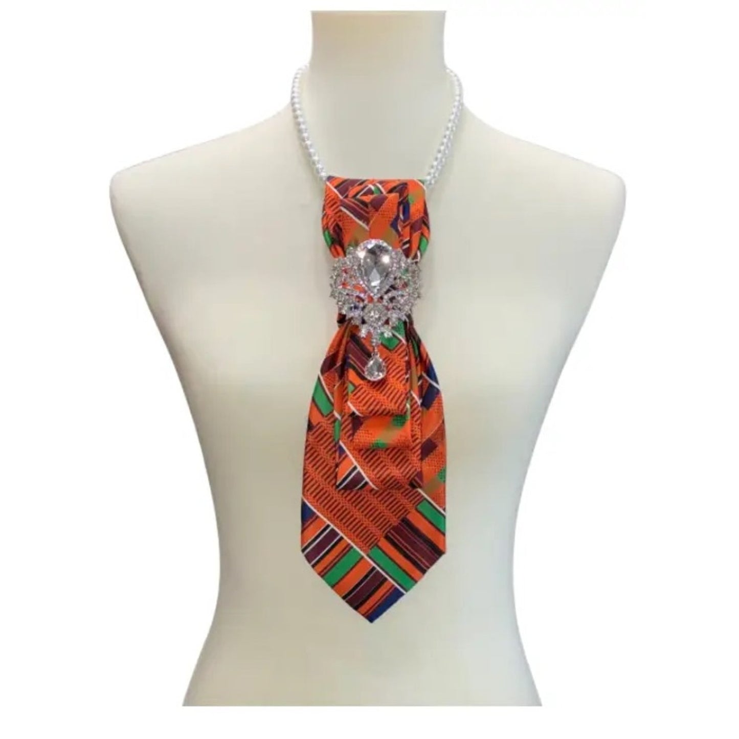 Colorful patterned tie with a decorative clasp on a mannequin against a white background