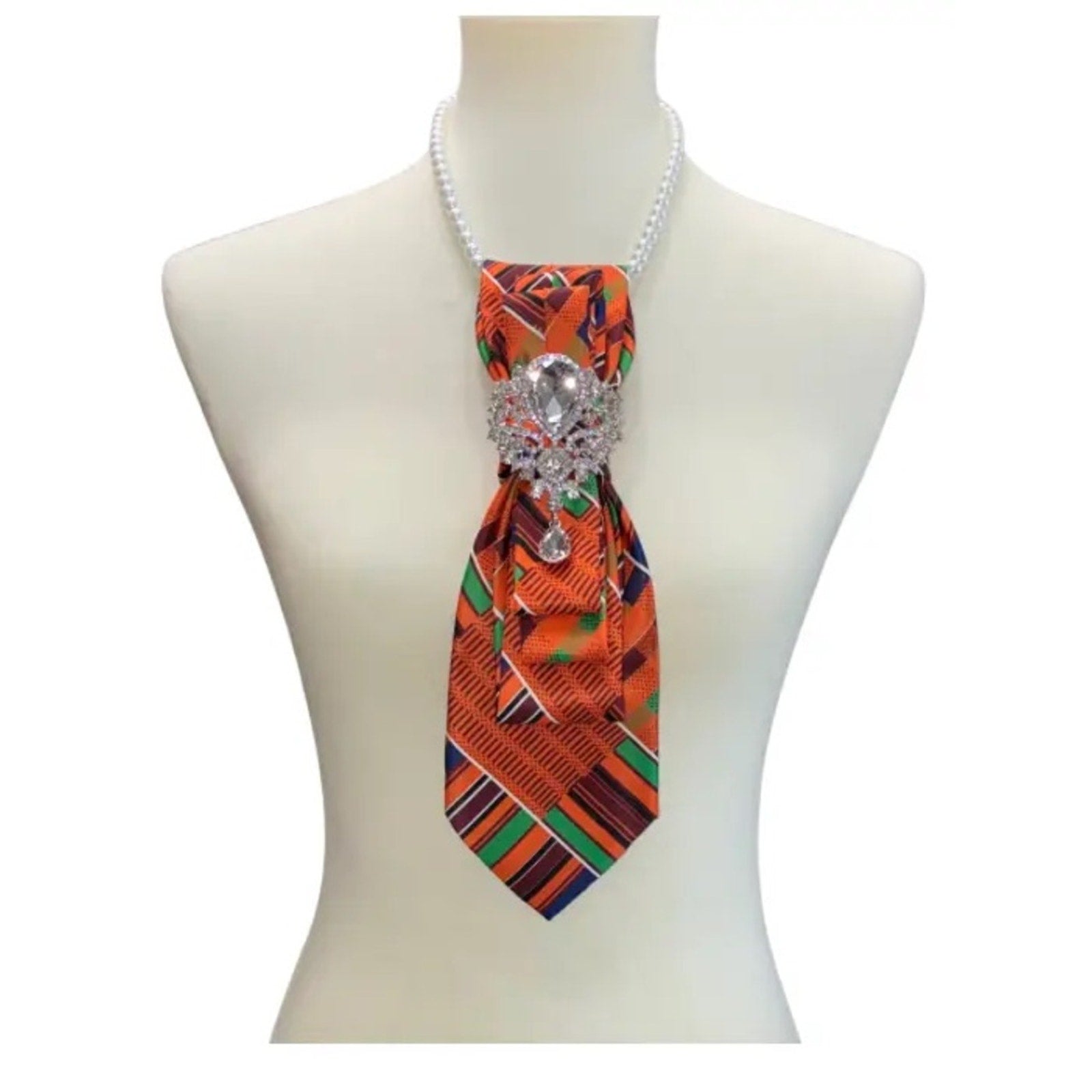 Colorful patterned tie with a decorative clasp on a mannequin against a white background
