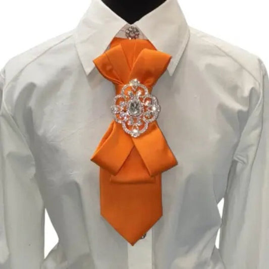 Orange tie with decorative brooch on a white shirt against a white background