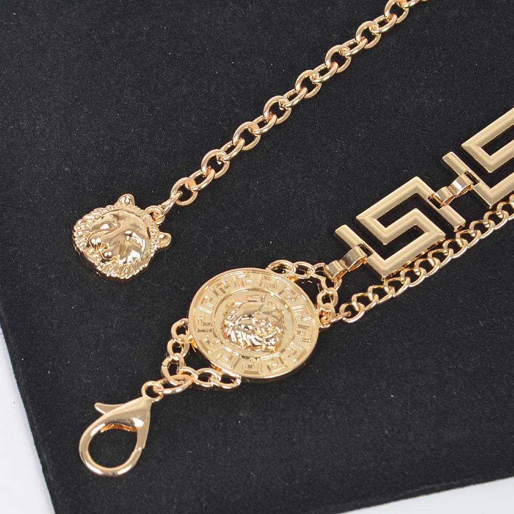 Gold bracelet with decorative clasp on a black background