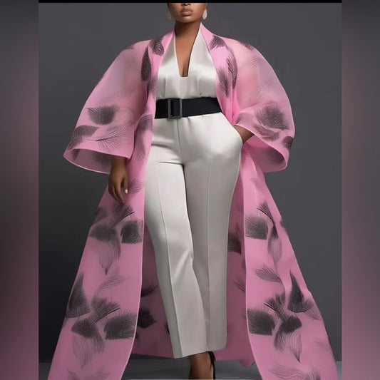 Person wearing a white outfit with a pink floral coat against a gray background