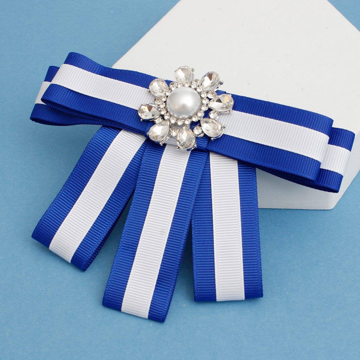 Blue and white striped ribbon bow with a decorative brooch on a blue background