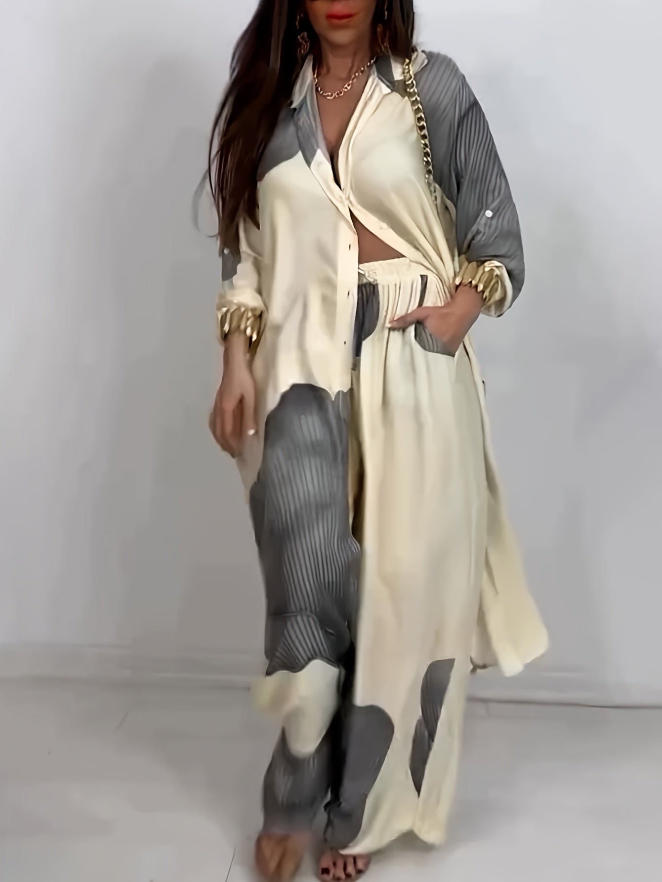 Woman wearing a long beige and gray dress with a white background