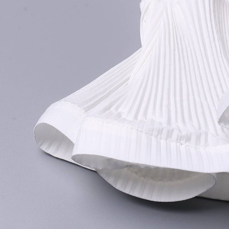 Close-up of a white pleated skirt on a gray background