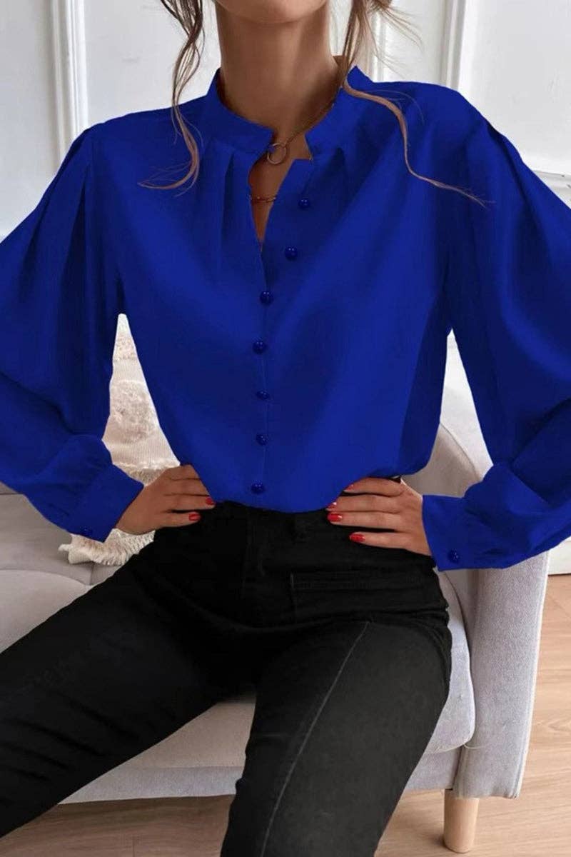 Person wearing a blue blouse sitting on a chair indoors.