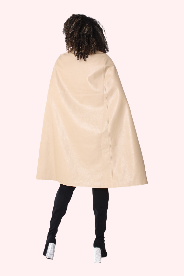 Person wearing a beige cape on a white background