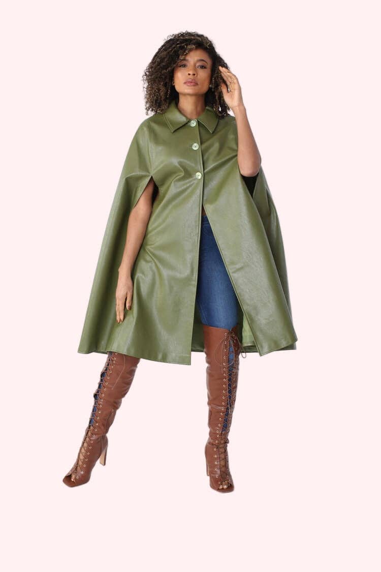Woman wearing a green cape over a blue dress with brown knee-high boots on a white background